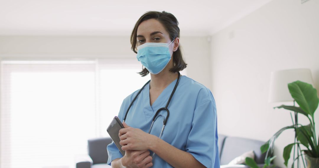 Confident Female Nurse Wearing Scrubs and Mask at Work - Free Images, Stock Photos and Pictures on Pikwizard.com