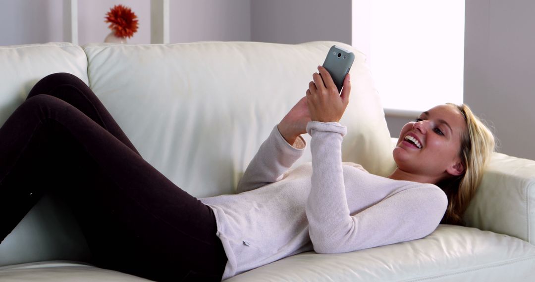 Woman Relaxing on Sofa while Using Smartphone Indoors - Free Images, Stock Photos and Pictures on Pikwizard.com