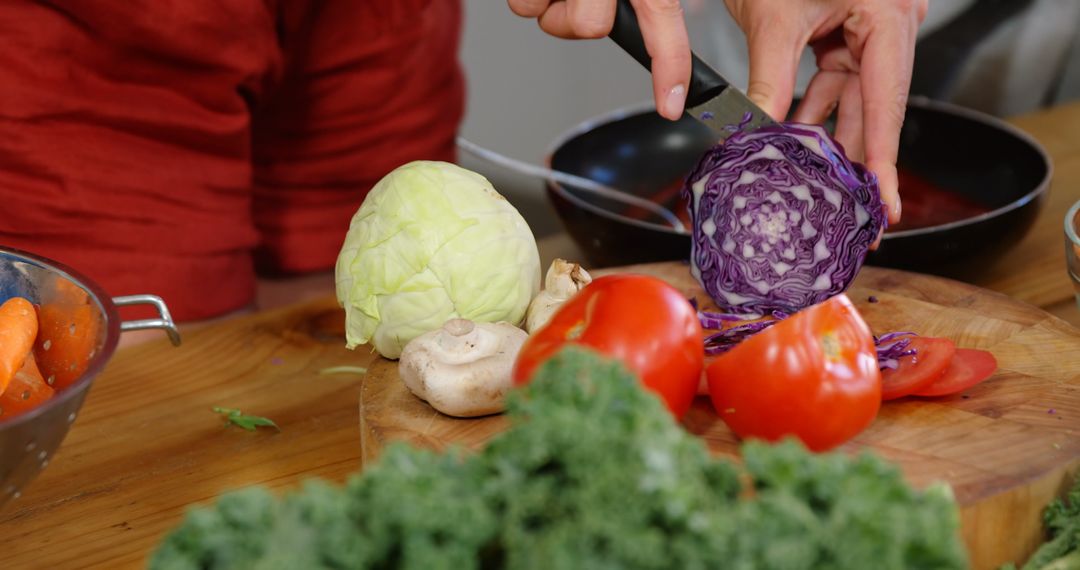 Person Cutting Purple Cabbage with Other Fresh Vegetables on Wooden Board - Free Images, Stock Photos and Pictures on Pikwizard.com