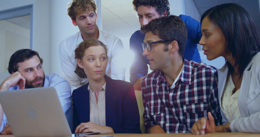 Team Collaboration in Modern Office around Laptop Discussion
