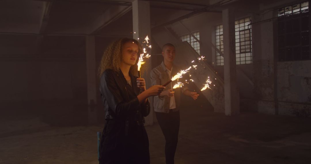 Friends Holding Sparklers in Dark Industrial Space Celebrating - Free Images, Stock Photos and Pictures on Pikwizard.com