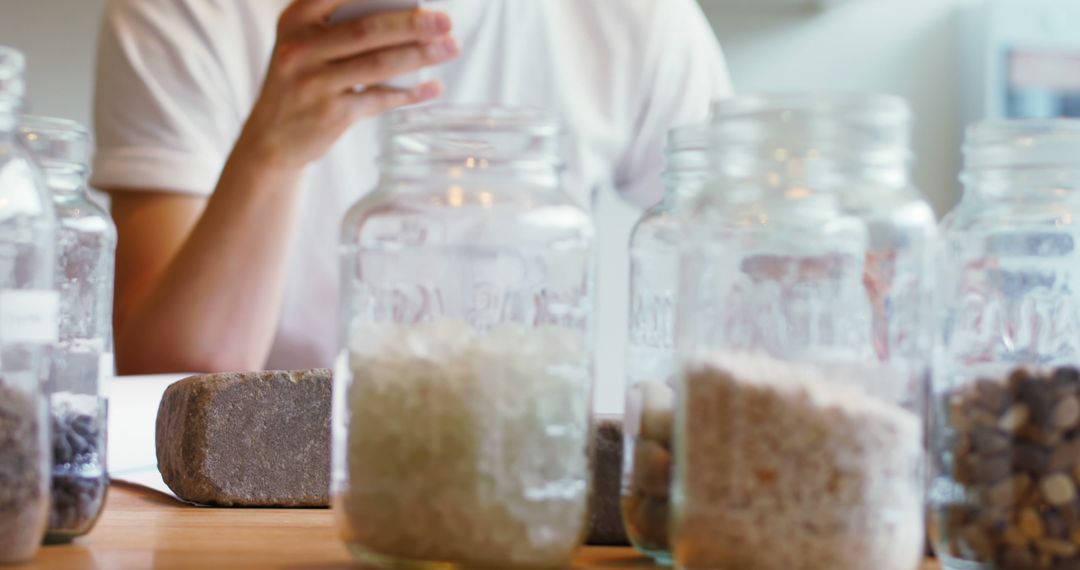 Man Using Smartphone Surrounded by Mason Jar Collection - Free Images, Stock Photos and Pictures on Pikwizard.com