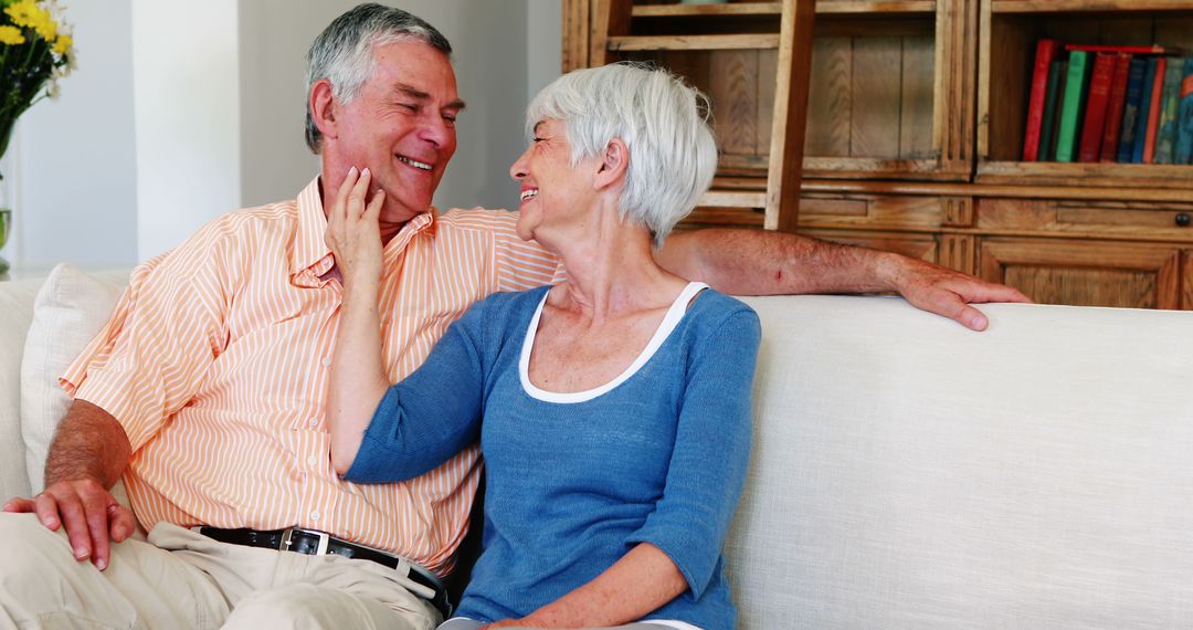 Happy Senior Couple Relaxing on Sofa at Home