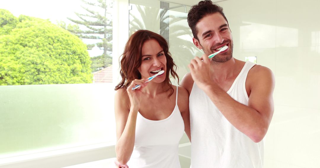 Healthy Smiling Couple Brushing Teeth in Bright Modern Bathroom - Free Images, Stock Photos and Pictures on Pikwizard.com