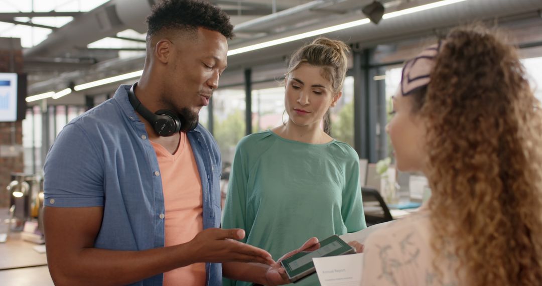 Diverse Colleagues Discussing Project with Tablet Technology in Modern Office