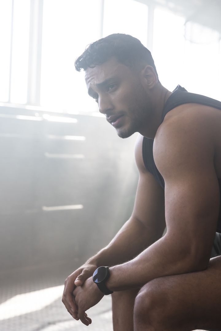 Determined Athlete Resting on Gym Bench in Industrial Setting