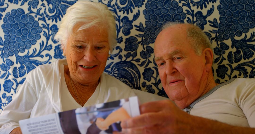 Senior Couple Reading Book Together in Cozy Bedroom - Free Images, Stock Photos and Pictures on Pikwizard.com