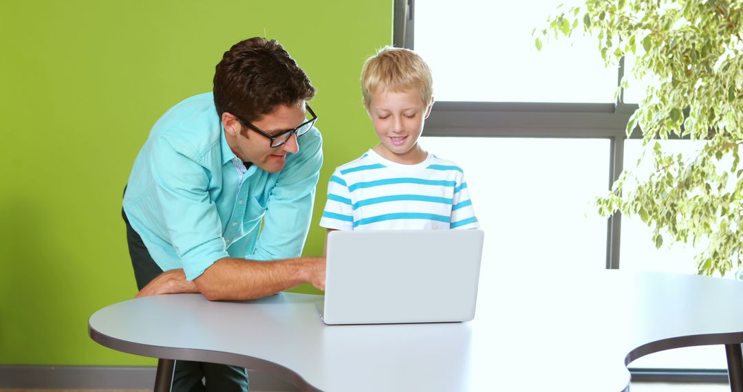 Teacher Helping Student with Laptop Computer in Classroom - Free Images, Stock Photos and Pictures on Pikwizard.com