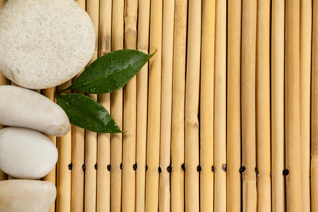Zen Spa Setting with Bamboo Mat, Stones, and Green Leaves - Free Images, Stock Photos and Pictures on Pikwizard.com