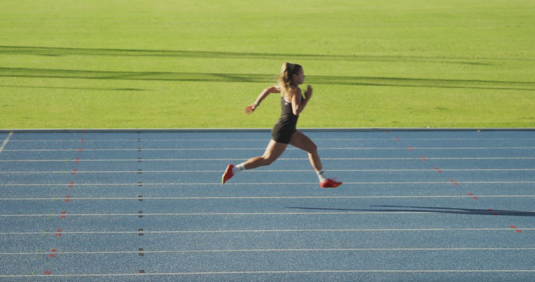 Female athlete sprinting on track under sunshine - Free Images, Stock Photos and Pictures on Pikwizard.com