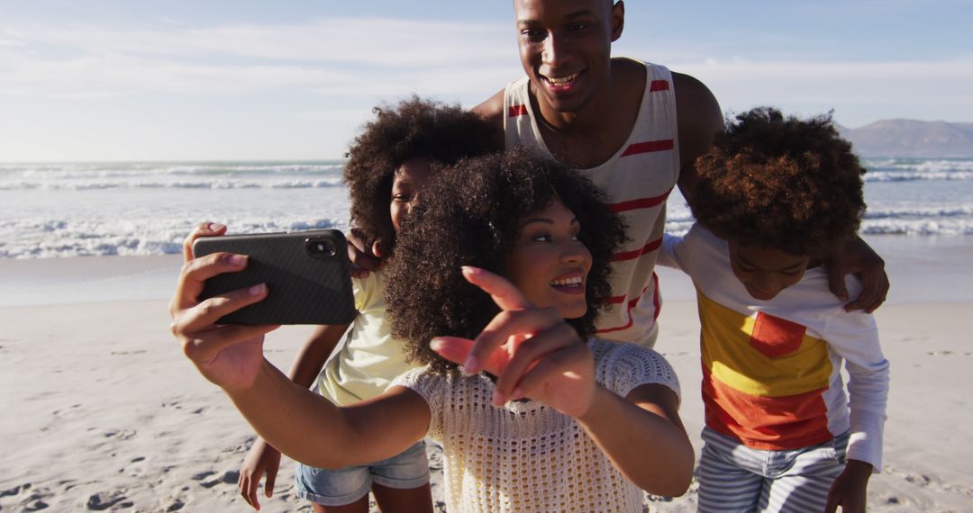 African american parents and their children taking a selfie with smartphone on the beach - Free Images, Stock Photos and Pictures on Pikwizard.com
