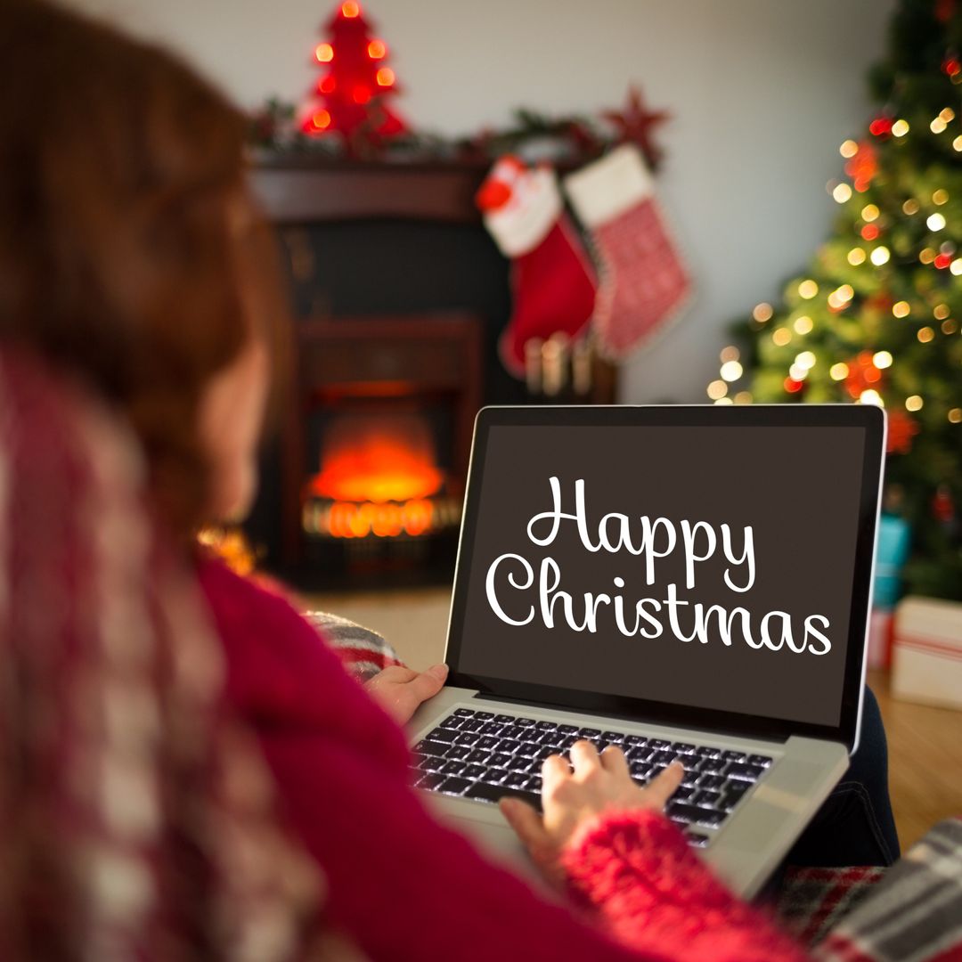 Person Celebrating Christmas Typing on Laptop with Holiday Message