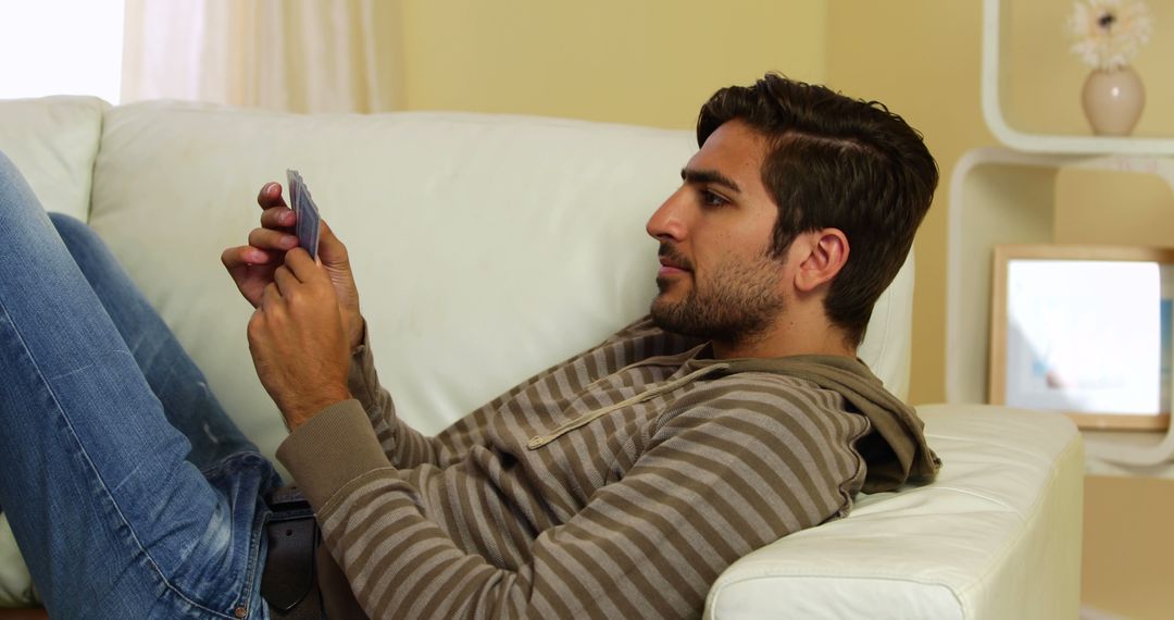 Man Relaxing on Sofa and Using Smartphone in Casual Setting - Free Images, Stock Photos and Pictures on Pikwizard.com