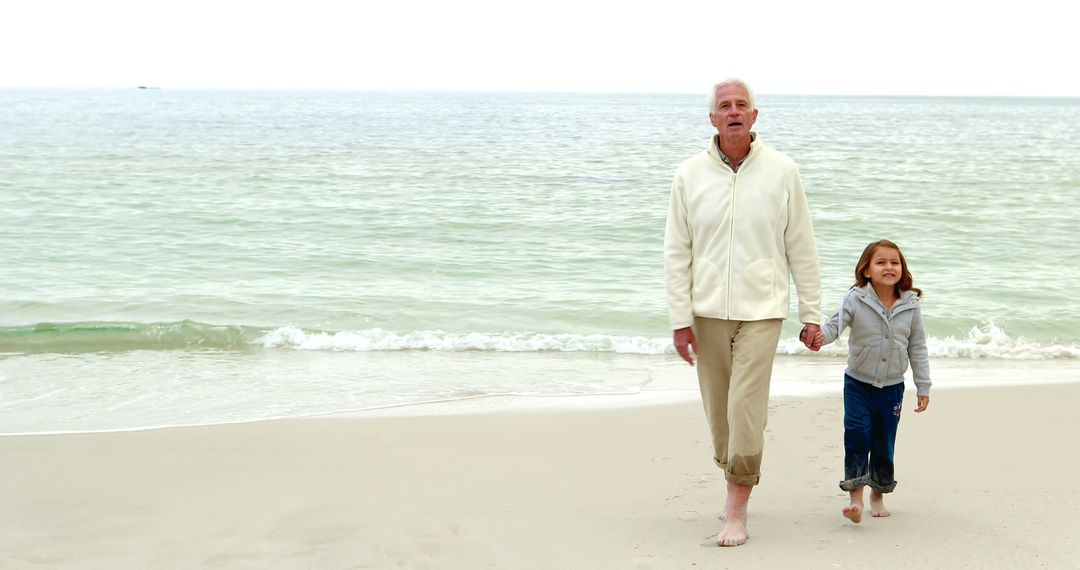 Grandfather and granddaughter walking together on the beach  - Free Images, Stock Photos and Pictures on Pikwizard.com