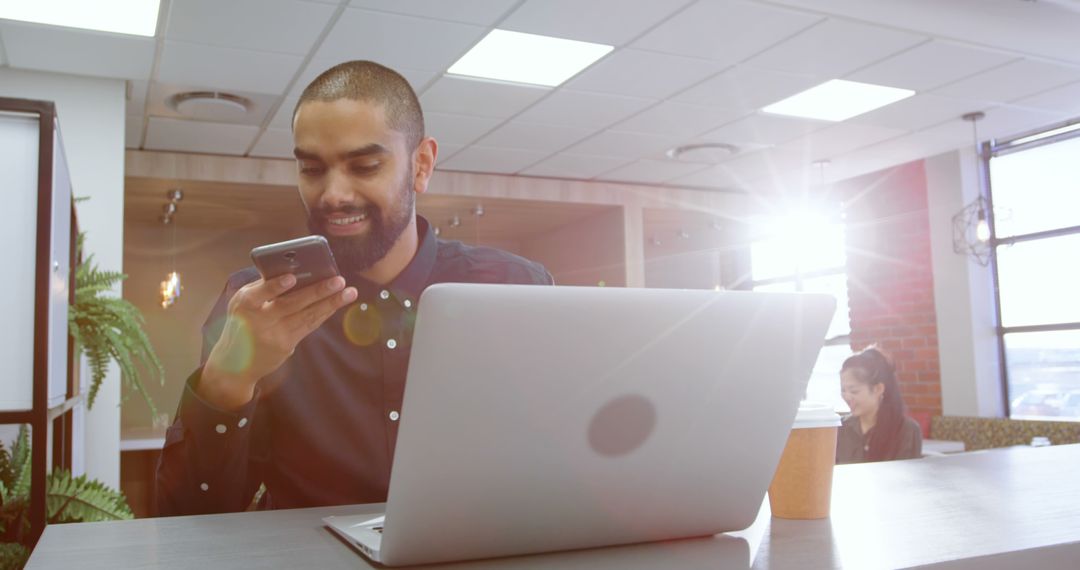 Businessman Working in Modern Office with Smartphone and Laptop
