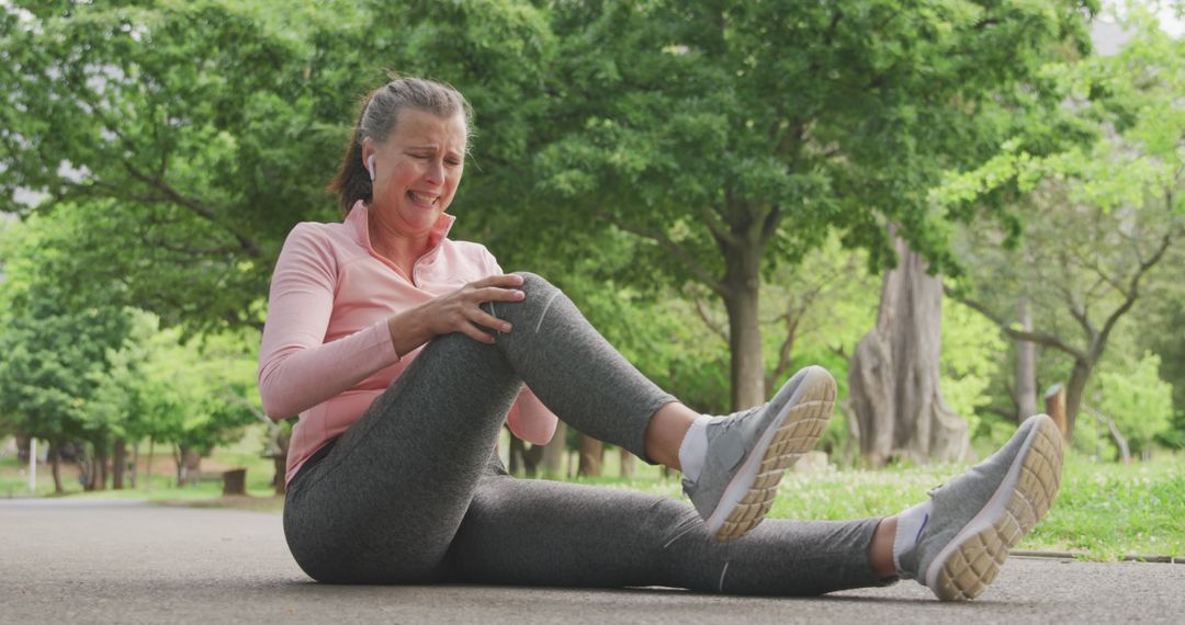 Older woman experiencing knee pain during outdoor exercise - Free Images, Stock Photos and Pictures on Pikwizard.com