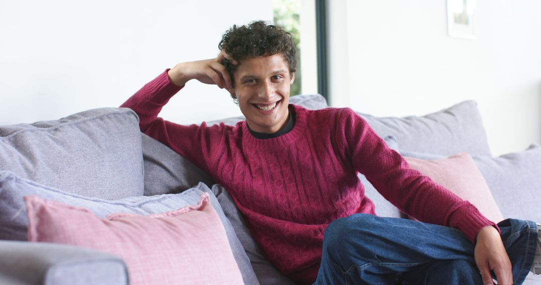 Smiling Young Man Relaxing on Cozy Sofa at Home - Free Images, Stock Photos and Pictures on Pikwizard.com