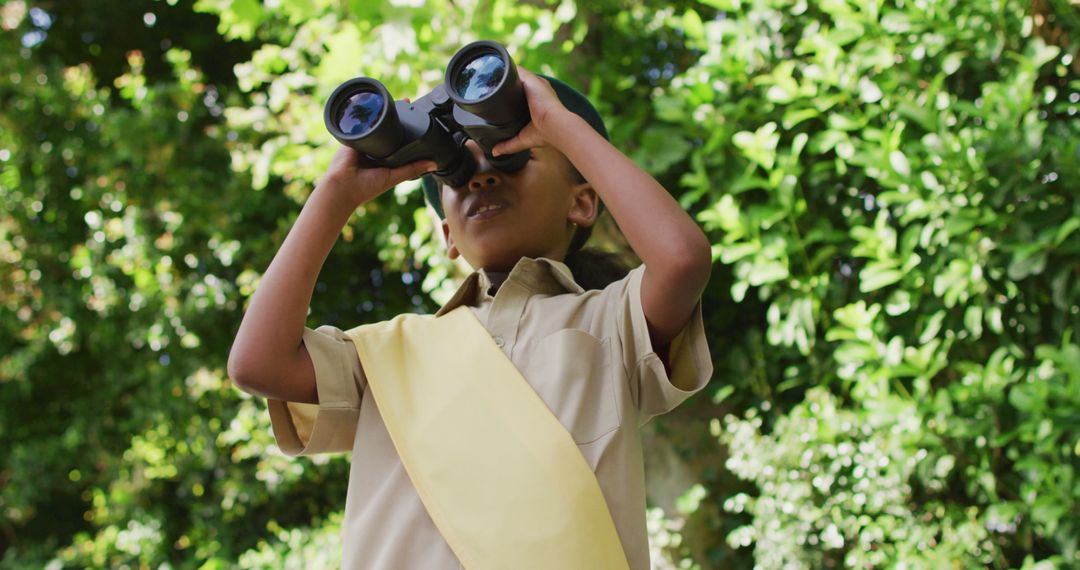 Curious Young Scout Observing Nature with Binoculars - Free Images, Stock Photos and Pictures on Pikwizard.com