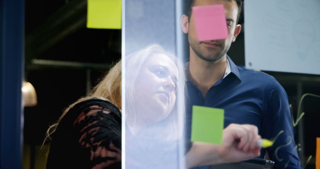 Businesspeople Brainstorming With Sticky Notes on Office Glass Wall - Free Images, Stock Photos and Pictures on Pikwizard.com