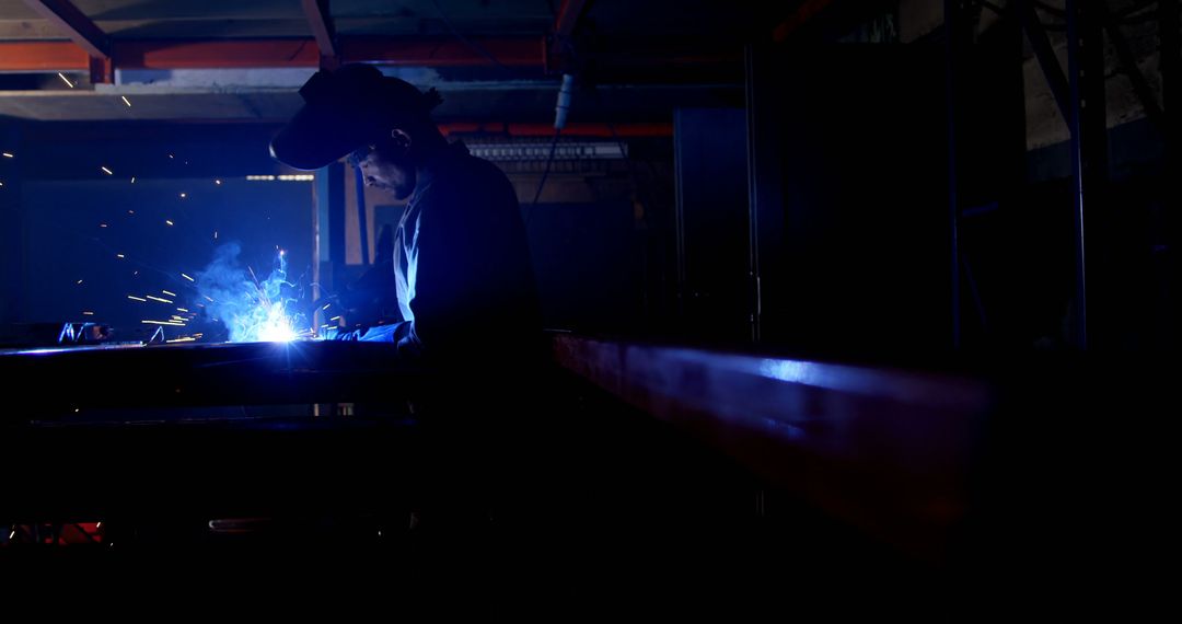 Welder in Action Creating Sparks in Dimly Lit Workshop - Free Images, Stock Photos and Pictures on Pikwizard.com