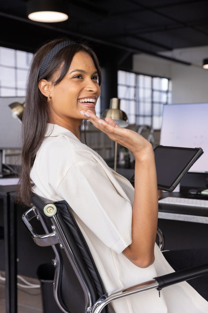 Smiling Asian Woman Sitting with Drawing Tablet in Modern Office