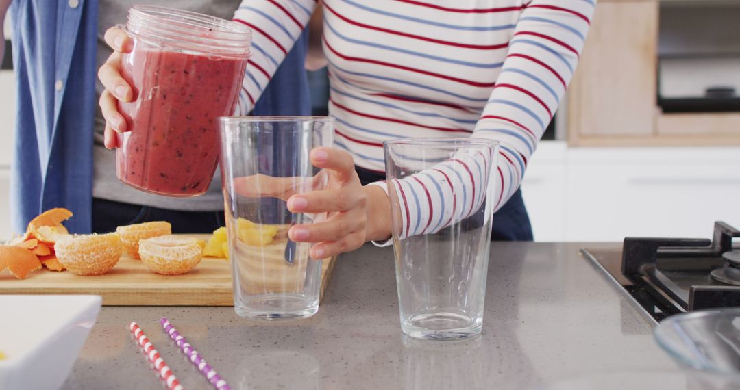 Image of midsection of diverse couple pouring juice into glasses - Free Images, Stock Photos and Pictures on Pikwizard.com
