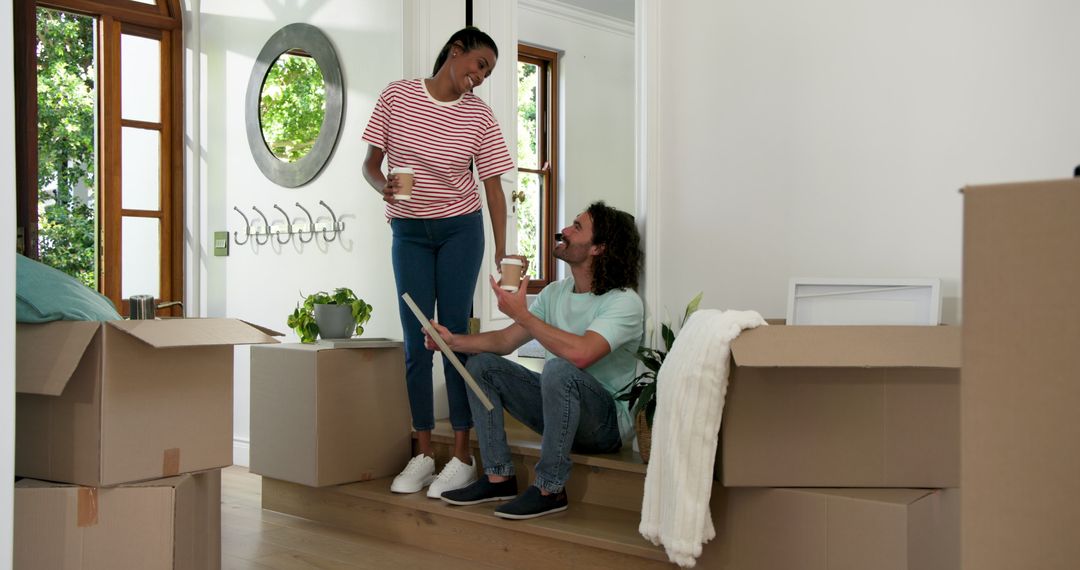 Cheerful Couple Enjoying Coffee Break Amidst Moving Boxes