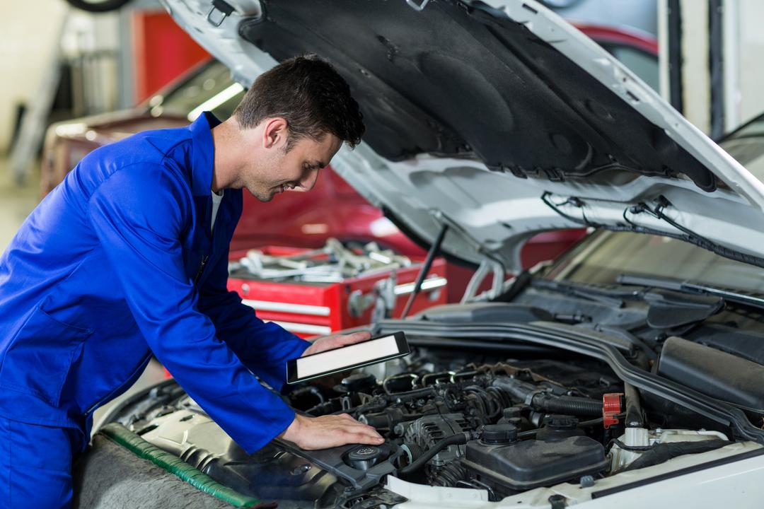 Mechanic Using Digital Tablet While Servicing Car Engine - Free Images, Stock Photos and Pictures on Pikwizard.com