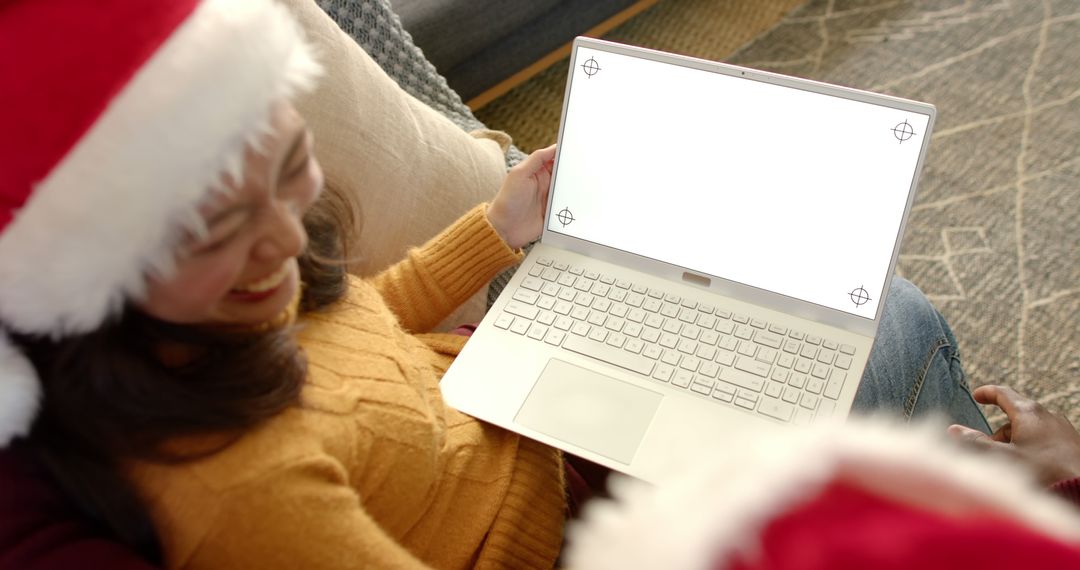 Woman in Santa Hat Using Laptop with Empty Screen During Holiday Season - Free Images, Stock Photos and Pictures on Pikwizard.com