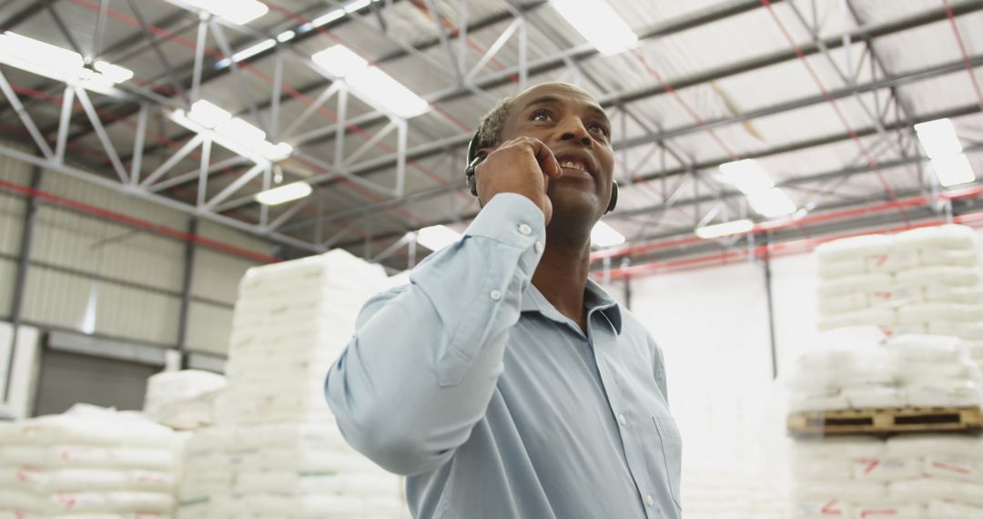 Confident Businessman Discussing Strategy in Warehouse - Free Images, Stock Photos and Pictures on Pikwizard.com