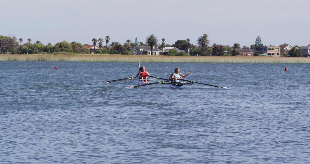 Two Women Rowing Kayak on Calm Lake Waters on Sunny Day - Free Images, Stock Photos and Pictures on Pikwizard.com