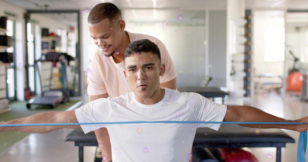 Personal Trainer Guiding Client Pulling Resistance Band for Shoulder Rehab and Strength Training