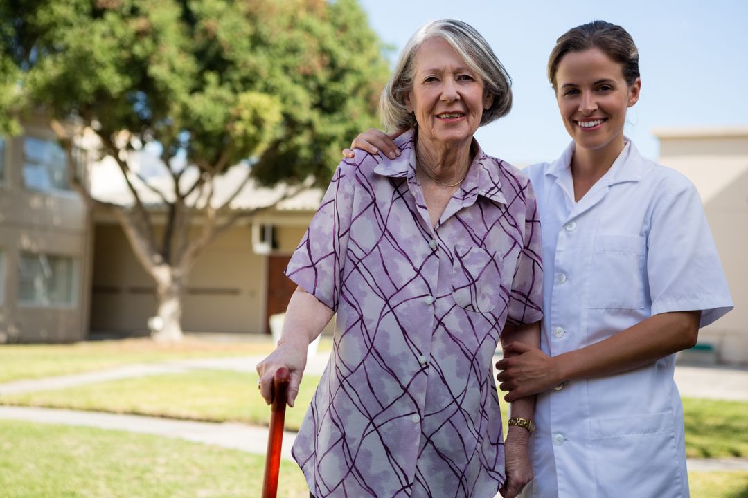 Smiling Nurse Assisting Elderly Woman Outdoors - Free Images, Stock Photos and Pictures on Pikwizard.com