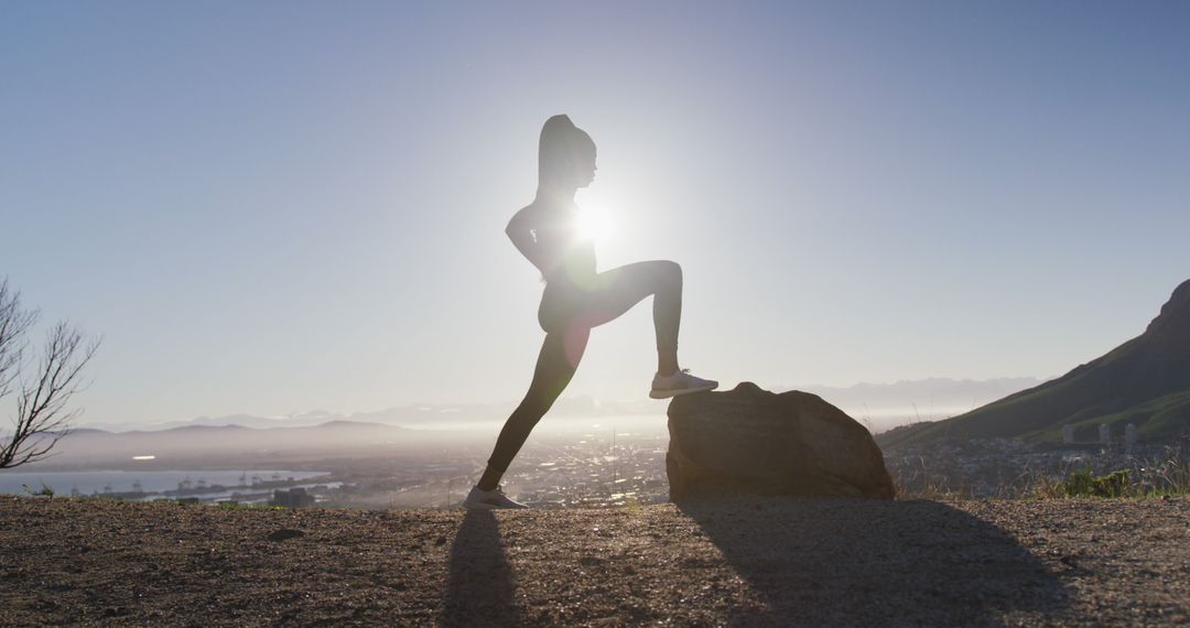 African american woman exercising outdoors stretching legs in countryside at sunset - Free Images, Stock Photos and Pictures on Pikwizard.com