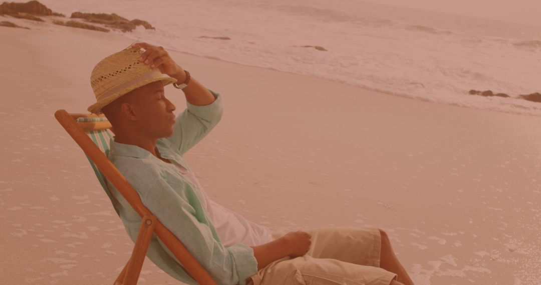 Man Relaxing on Beach in Summer Attire with Straw Hat - Free Images, Stock Photos and Pictures on Pikwizard.com