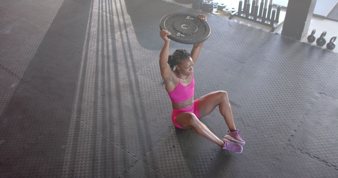 Woman's Athletic Exercise with Weight Plate in Gym