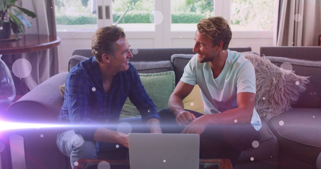 Father and Son Enjoying Together on Couch with Laptop