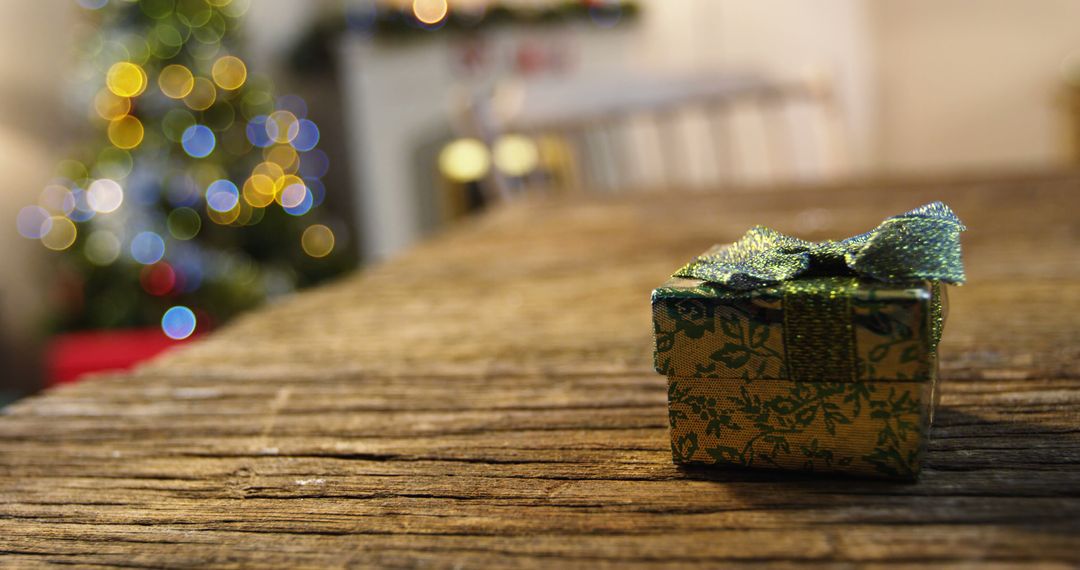 Small Gift Box with Bow on Wood Table with Festive Lights in Background - Free Images, Stock Photos and Pictures on Pikwizard.com