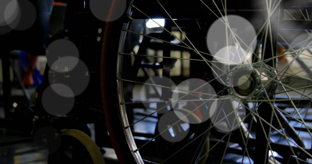 Close-Up of Wheelchair Wheel with Spokes in Dim Lighting