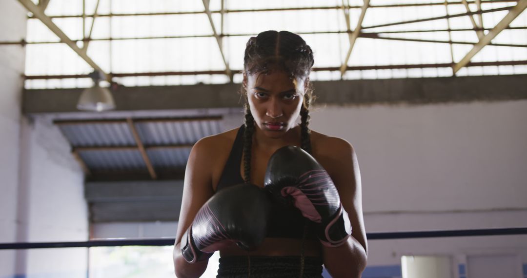 Confident biracial female boxer exudes strength in the ring, ready for competition. - Free Images, Stock Photos and Pictures on Pikwizard.com