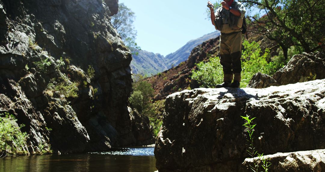 Hiker Fishing on Rocky Cliff by Mountain Stream - Free Images, Stock Photos and Pictures on Pikwizard.com