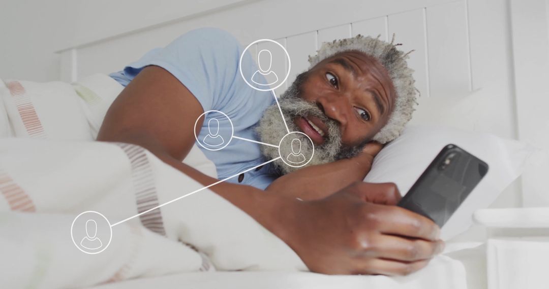 Senior Man Engaging with Social Networking on Smartphone in Bed