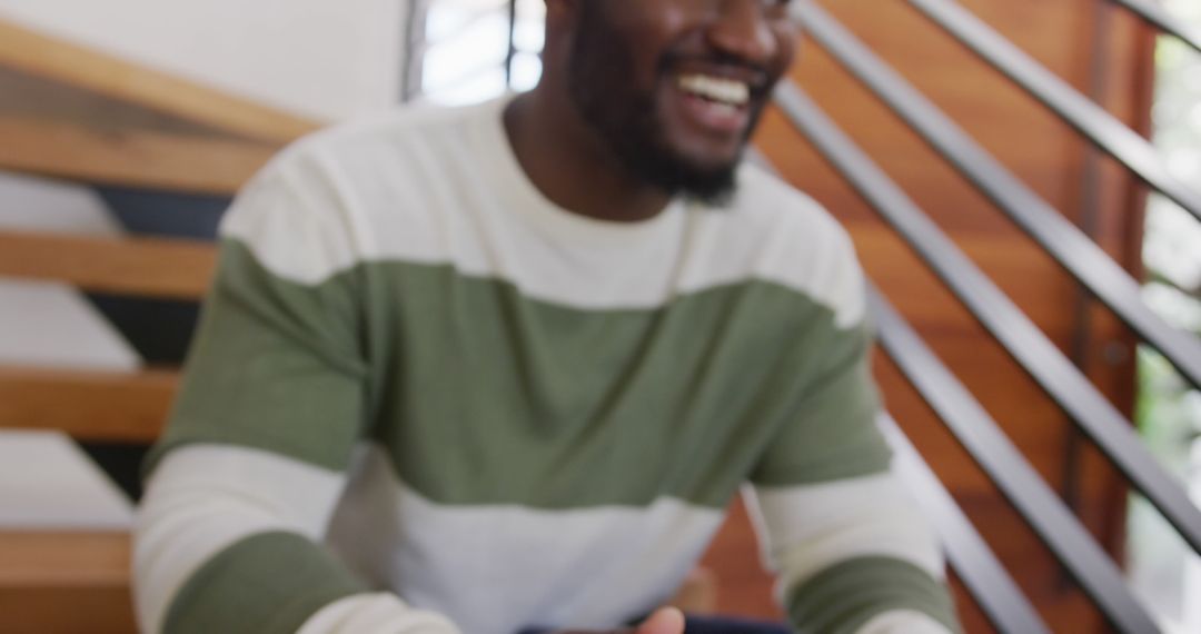 Smiling Man with Mobile Phone on Wooden Staircase - Free Images, Stock Photos and Pictures on Pikwizard.com