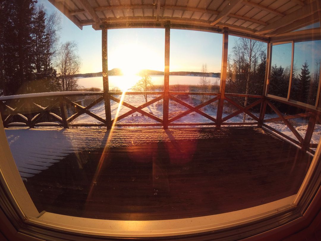 Scenic Winter Sunrise Over Frozen Lake from Cabin Porch - Free Images, Stock Photos and Pictures on Pikwizard.com