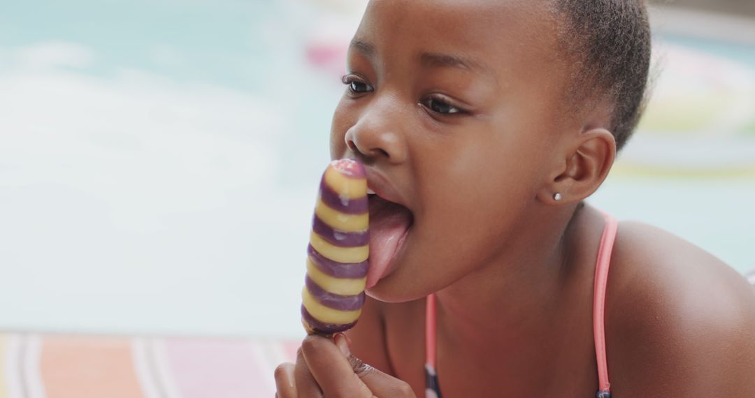 Young girl enjoying colorful popsicle by poolside - Free Images, Stock Photos and Pictures on Pikwizard.com