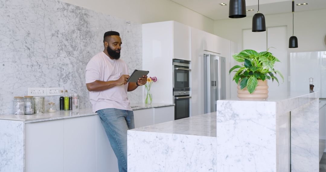 Man Relaxing in Modern Kitchen Marble Countertop with Tablet