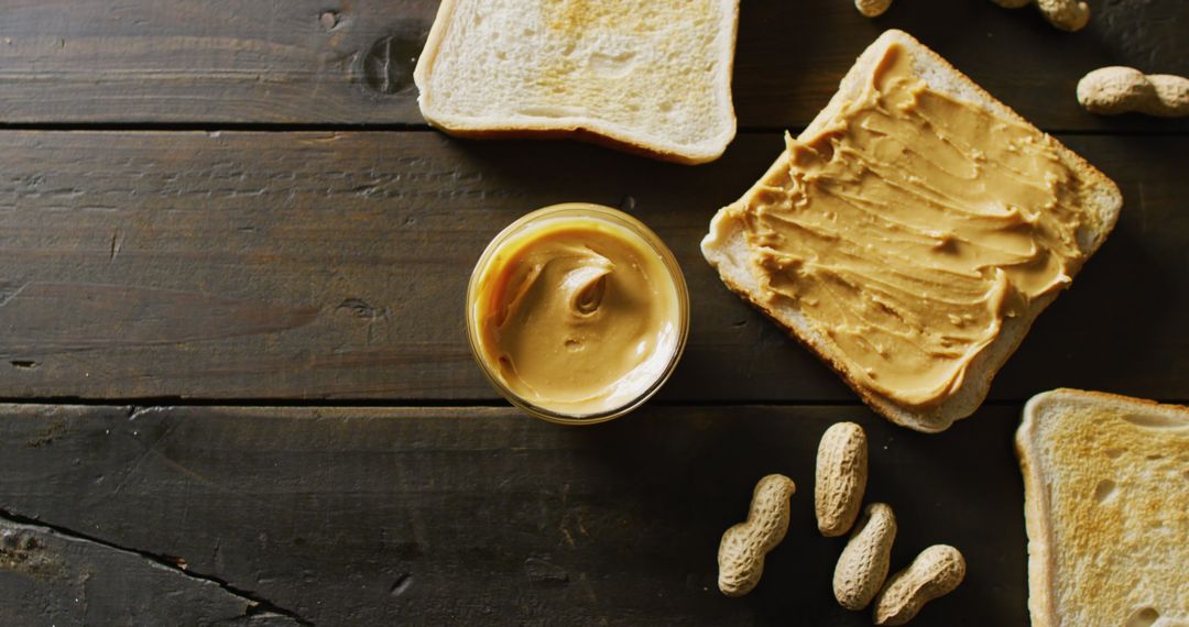 Toasts with Creamy Peanut Butter and Nuts on Rustic Wooden Table