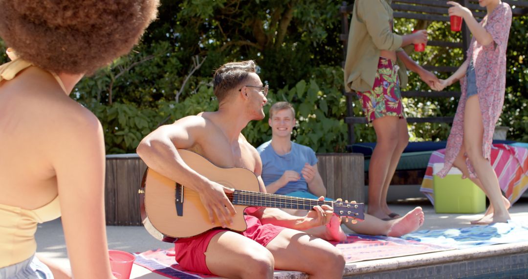 Young Friends Socializing and Playing Guitar by Poolside in Sunlight - Free Images, Stock Photos and Pictures on Pikwizard.com