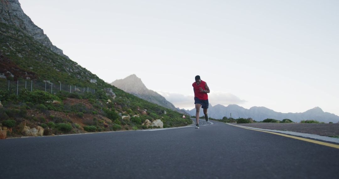 Man Running at Dusk on Scenic Mountain Road - Free Images, Stock Photos and Pictures on Pikwizard.com