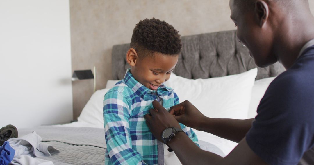 Image of happy african american father dressing up son in bedroom - Free Images, Stock Photos and Pictures on Pikwizard.com